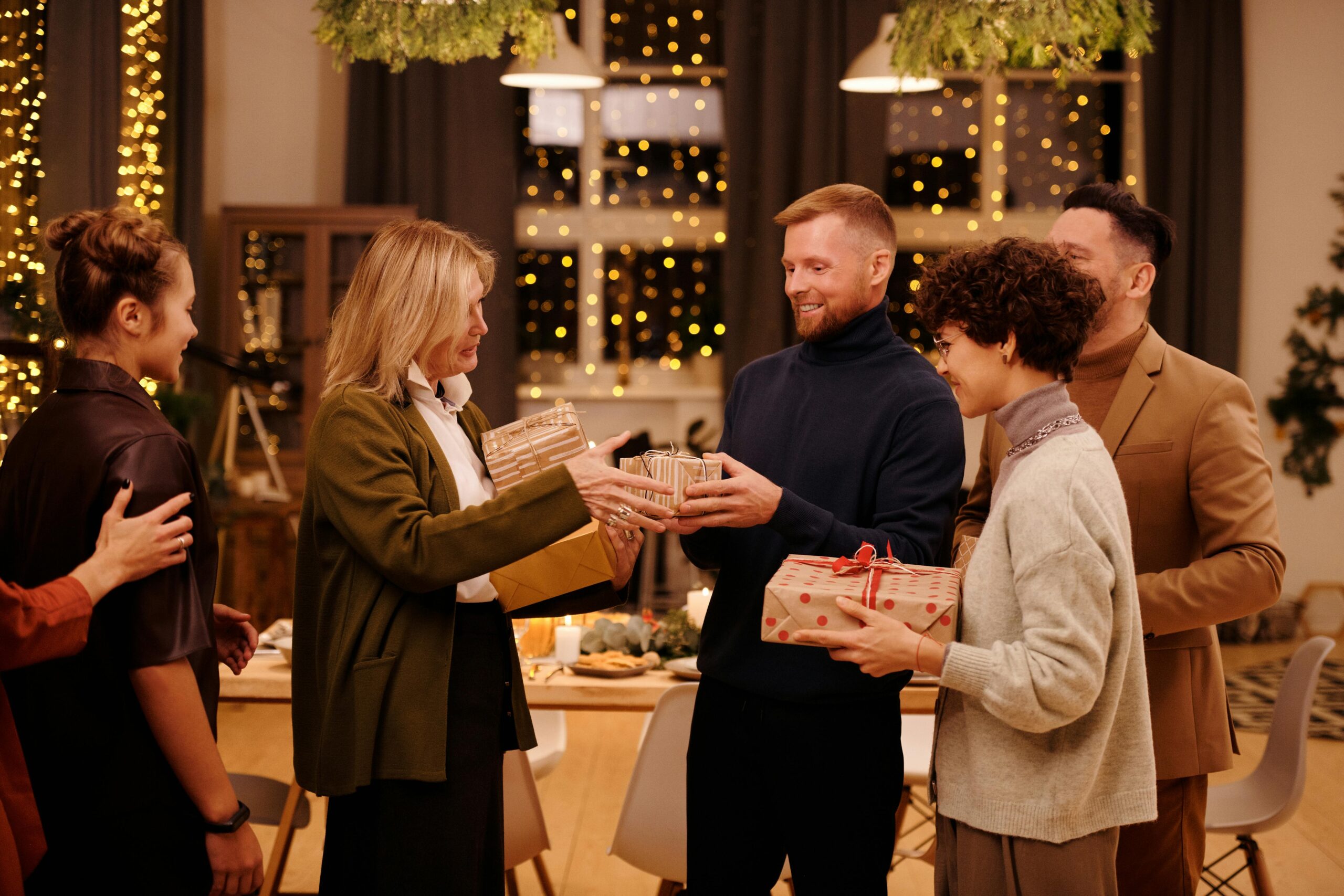 A warm and festive indoor family gathering with Christmas gift exchange and decorations.